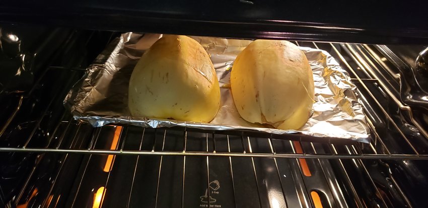 Two halves of spaghetti squash, baking, before being stuffed.